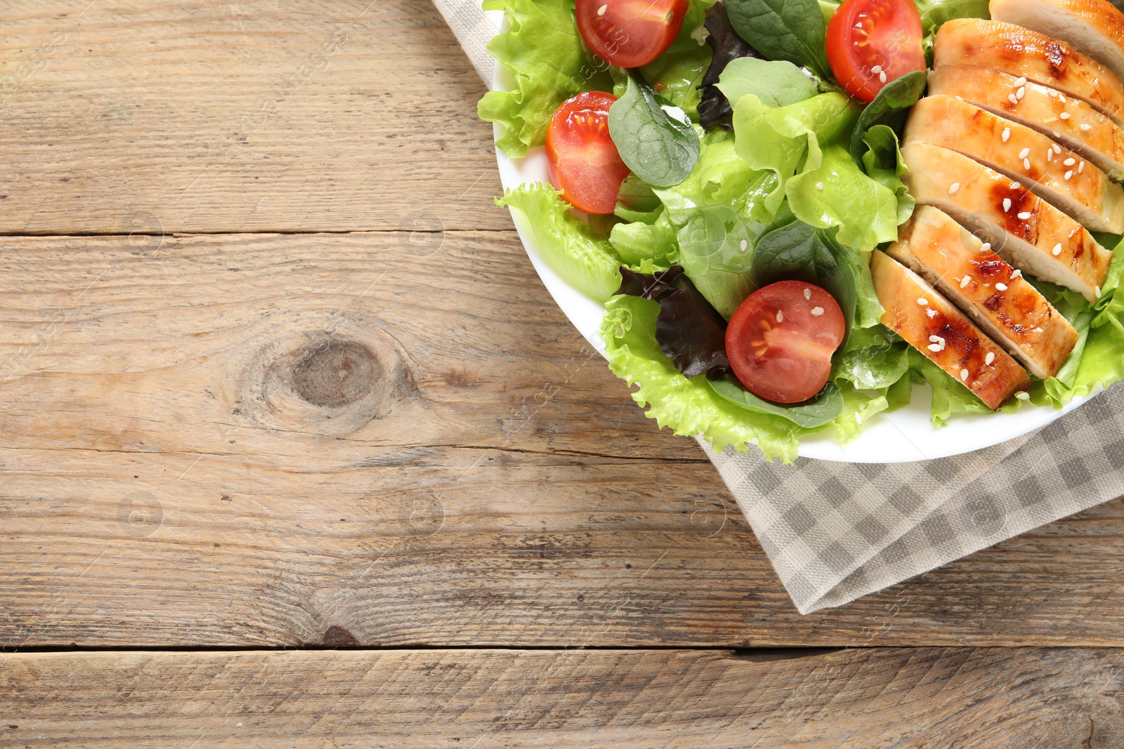 Photo of Delicious salad with chicken, cherry tomato and spinach on wooden table, top view. Space for text