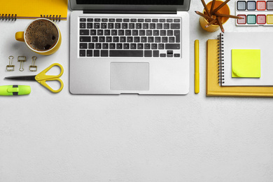 Flat lay composition with laptop and stationery on white table, space for text. Designer's workplace