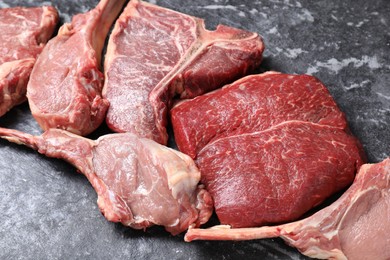 Photo of Fresh raw beef cuts on grey textured table