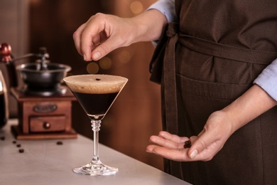 Photo of Woman preparing Espresso Martini on bar counter, closeup. Alcohol cocktail