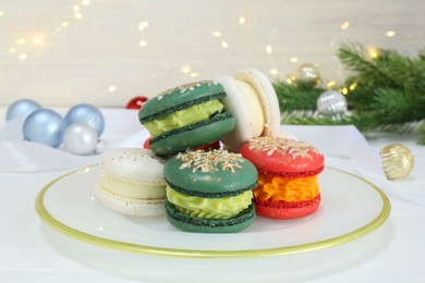 Photo of Different decorated Christmas macarons on white table