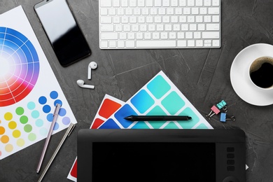 Photo of Flat lay composition with digital devices and color palettes on grey background. Graphic designer's workplace