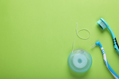 Photo of Flat lay composition with dental floss and different teeth care products on green background, space for text