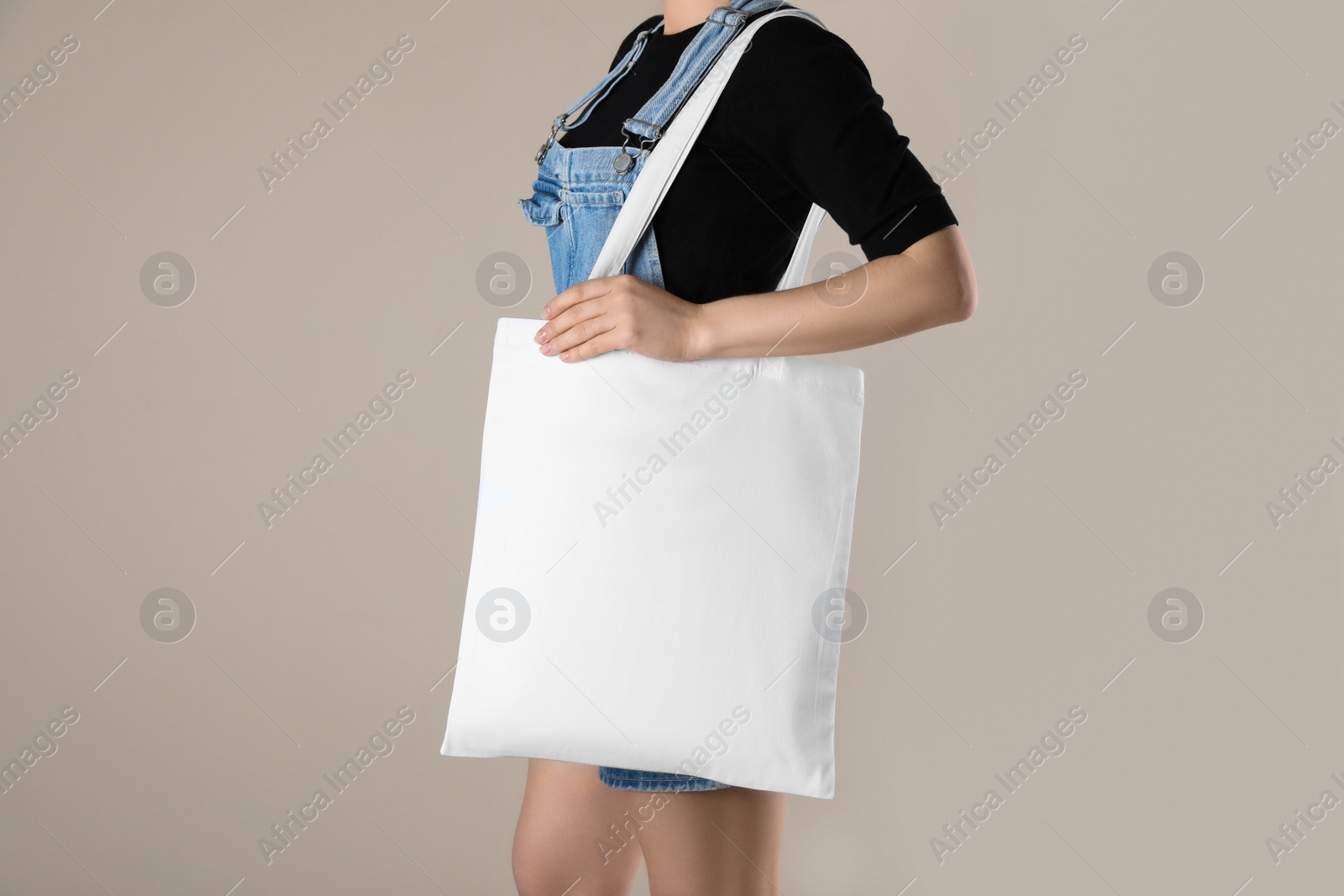 Photo of Woman with textile bag on beige background, closeup. Space for design