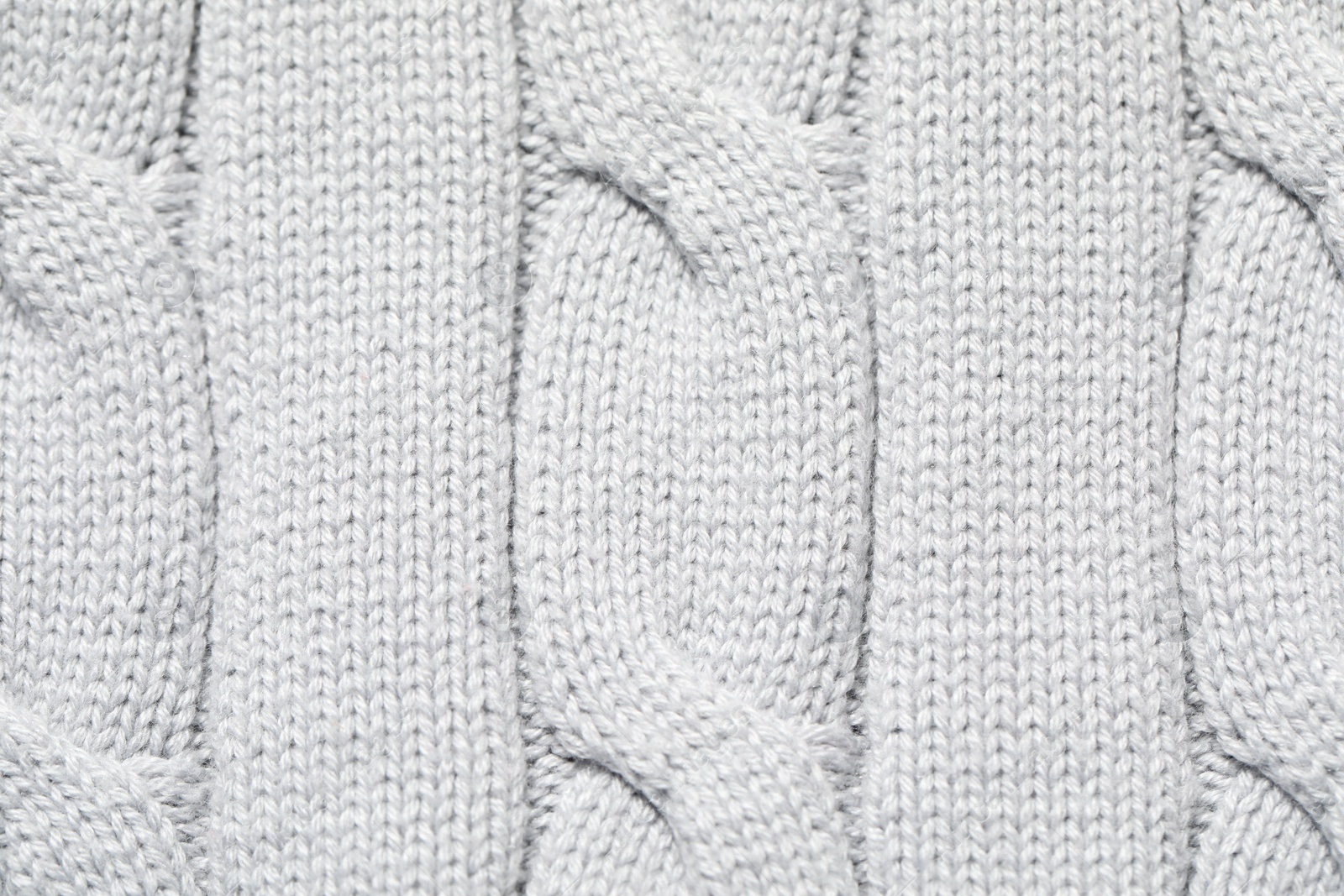 Photo of Texture of soft light knitted fabric as background, top view