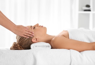 Photo of Relaxed woman receiving head massage in wellness center