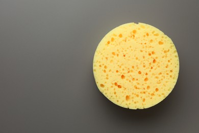 New yellow sponge on grey background, top view. Space for text