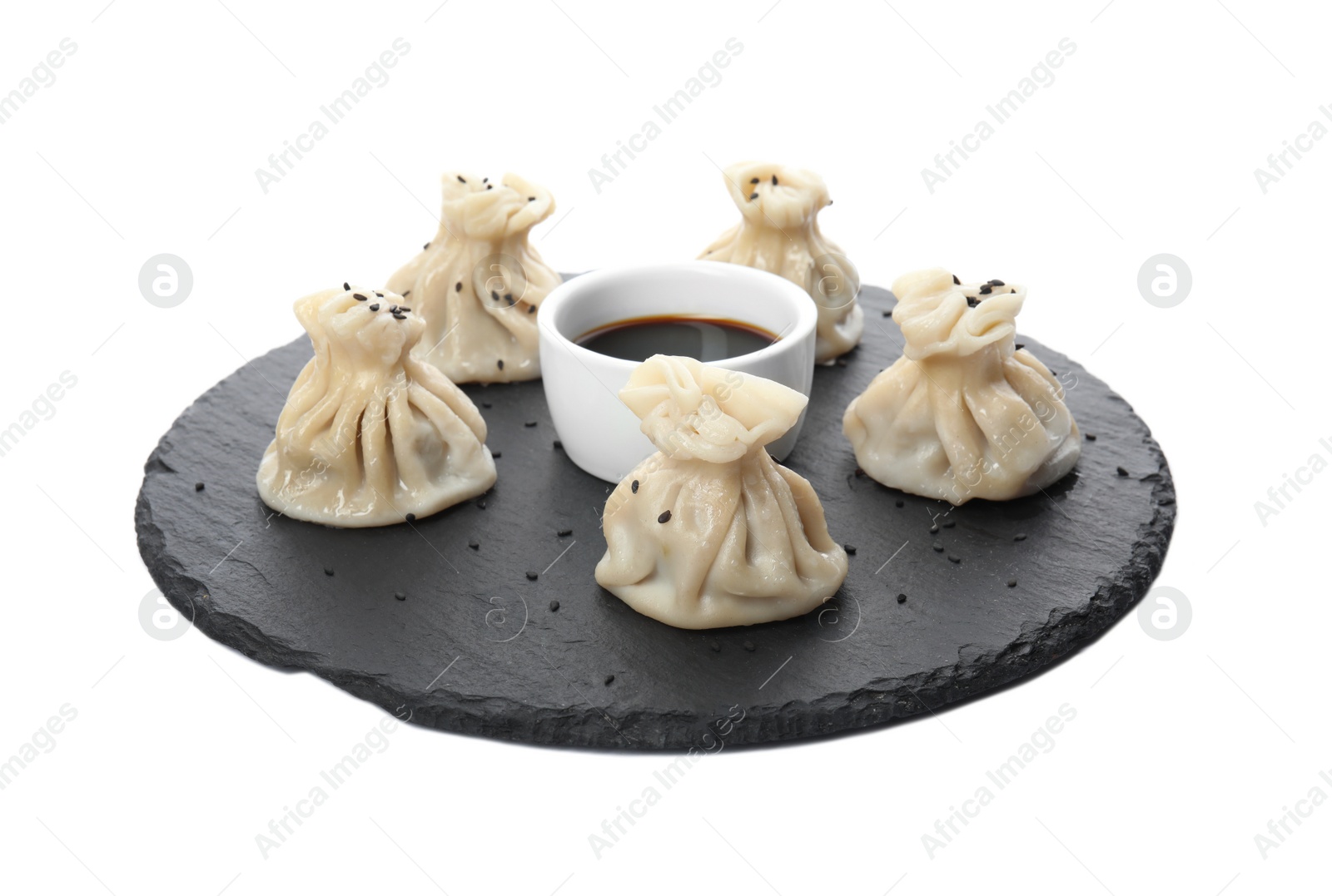 Photo of Slate plate with tasty baozi dumplings and soy sauce on white background