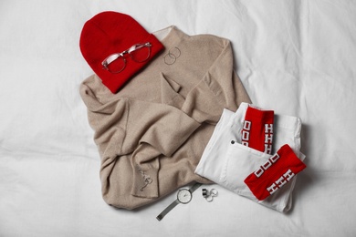 Photo of Stylish look with cashmere sweater, flat lay. Women's clothes and accessories on fabric