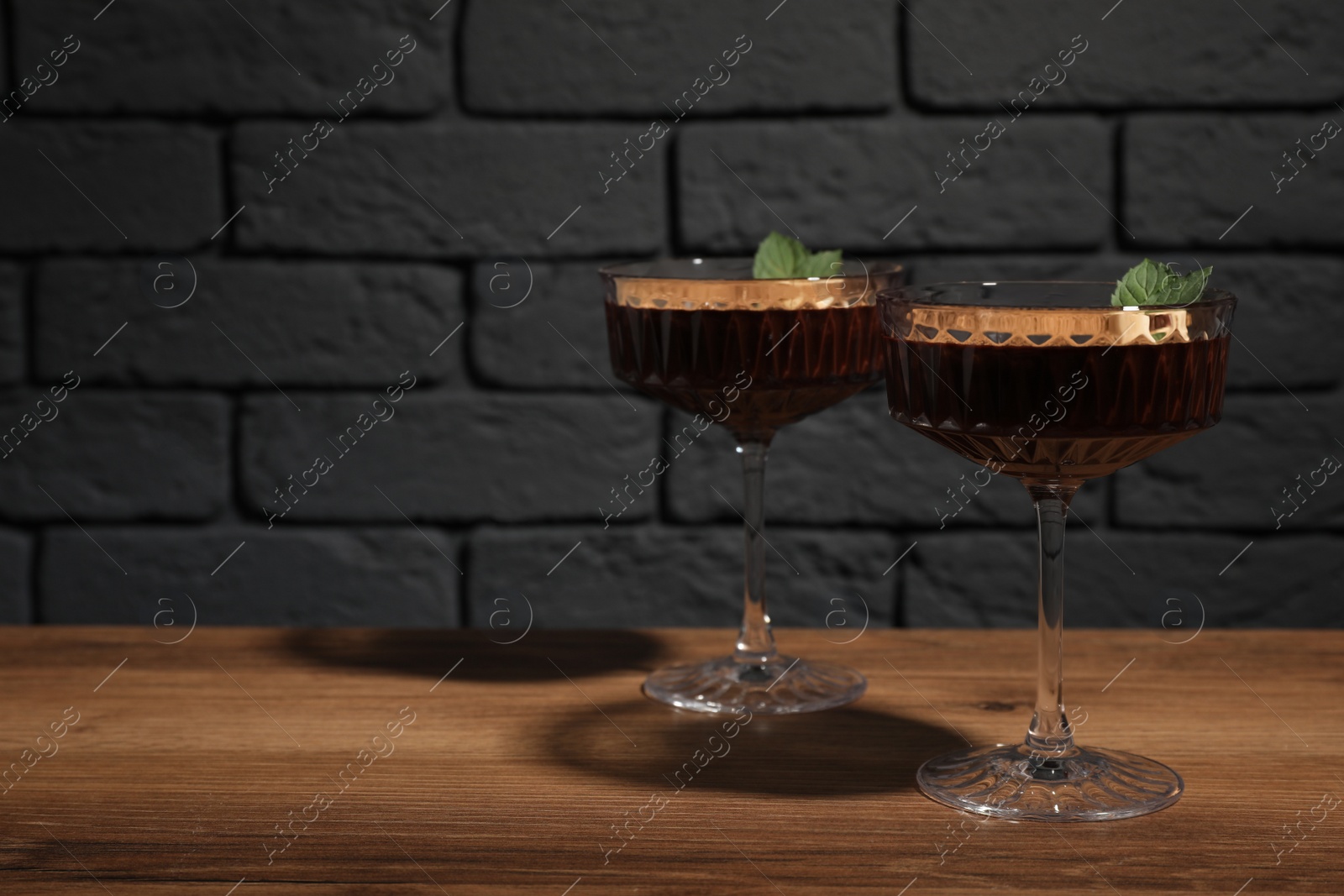 Photo of Dessert bowls of delicious hot chocolate with hazelnuts and fresh mint on wooden table. Space for text