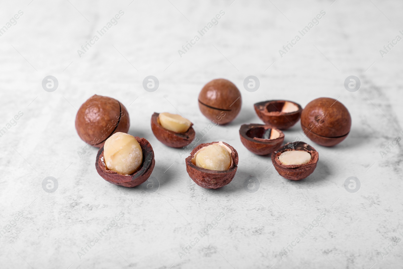 Photo of Delicious organic Macadamia nuts on white textured table