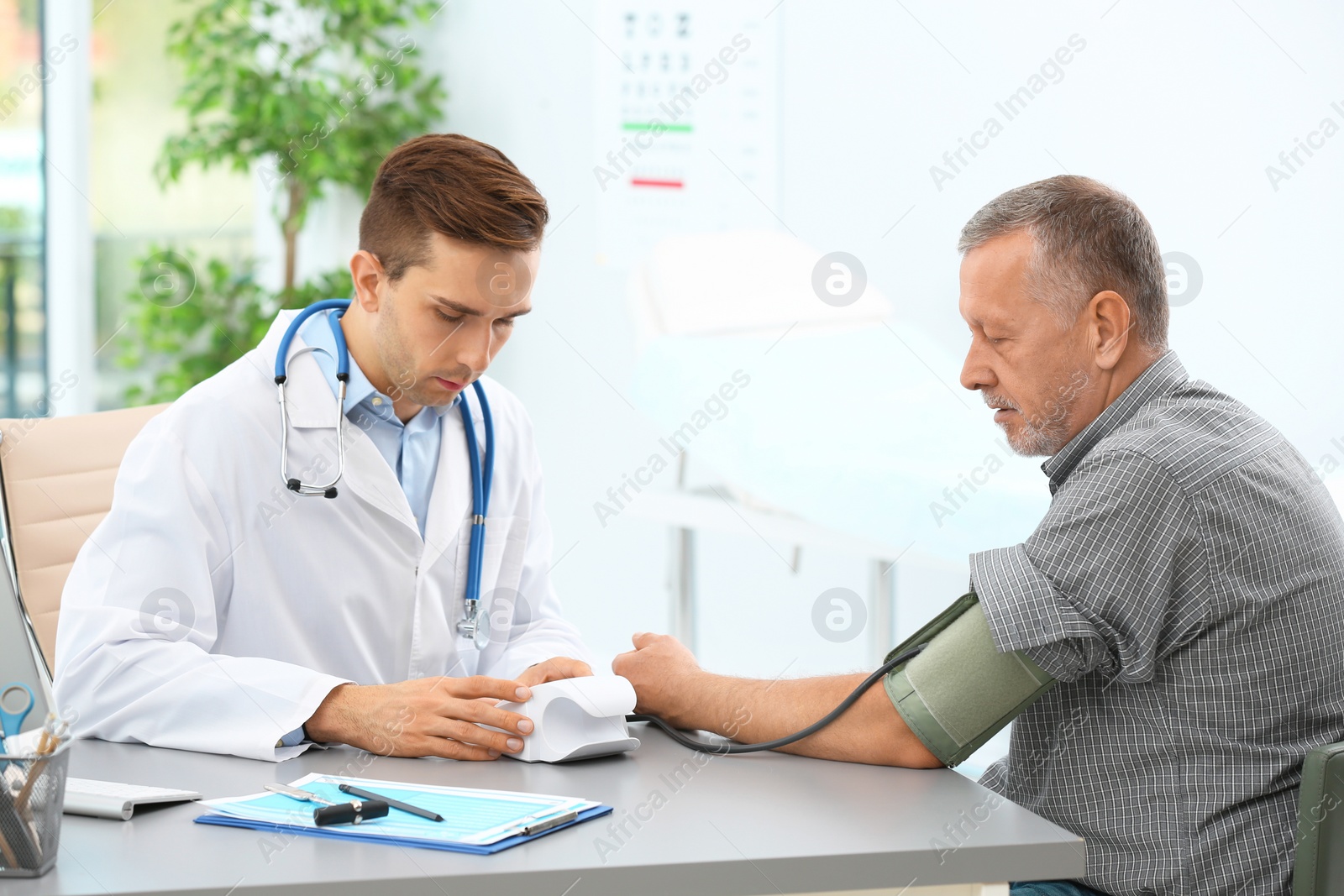 Photo of Doctor measuring blood pressure of mature patient in hospital