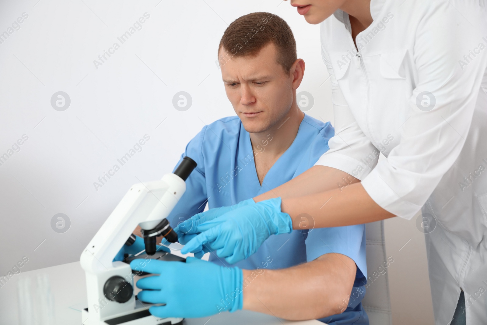 Photo of Medical students working with modern microscope in laboratory