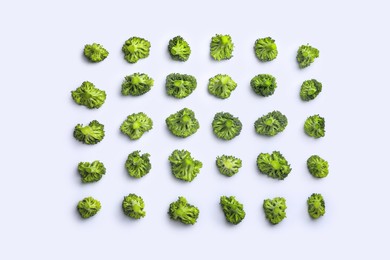 Photo of Many fresh green broccoli pieces on white background, flat lay