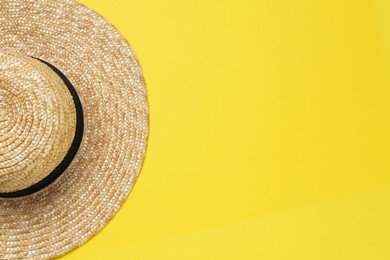 Straw hat on yellow background, top view with space for text. Sun protection