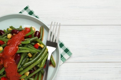 Delicious salad with green beans and tomato sauce served on white wooden table, top view. Space for text