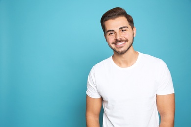 Photo of Portrait of young man laughing on color background. Space for text