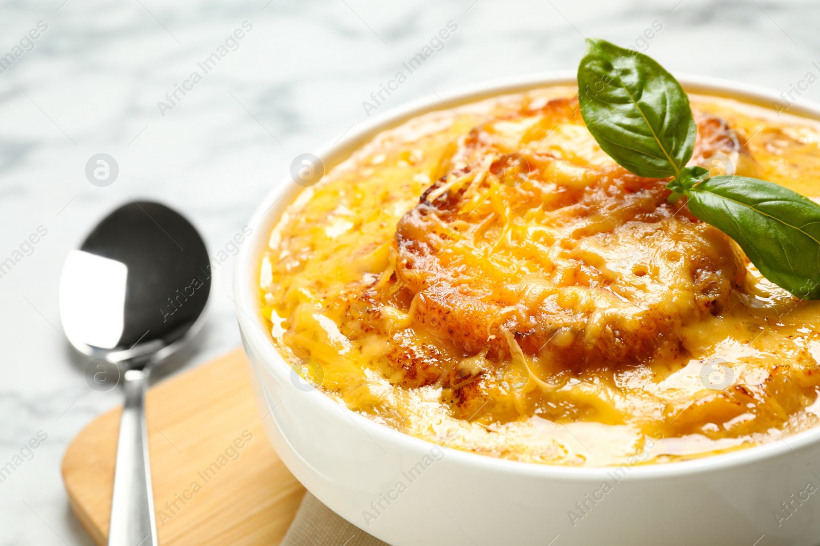 Photo of Tasty homemade french onion soup served on table, closeup