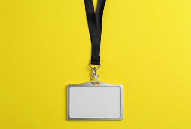 Photo of Blank badge on yellow background, top view. Mockup for design