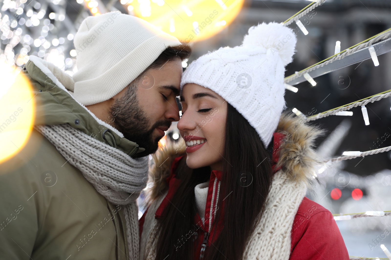 Photo of Happy young couple spending time together at winter fair. Christmas celebration