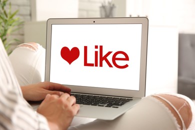 Woman using laptop with word Like on screen indoors, closeup