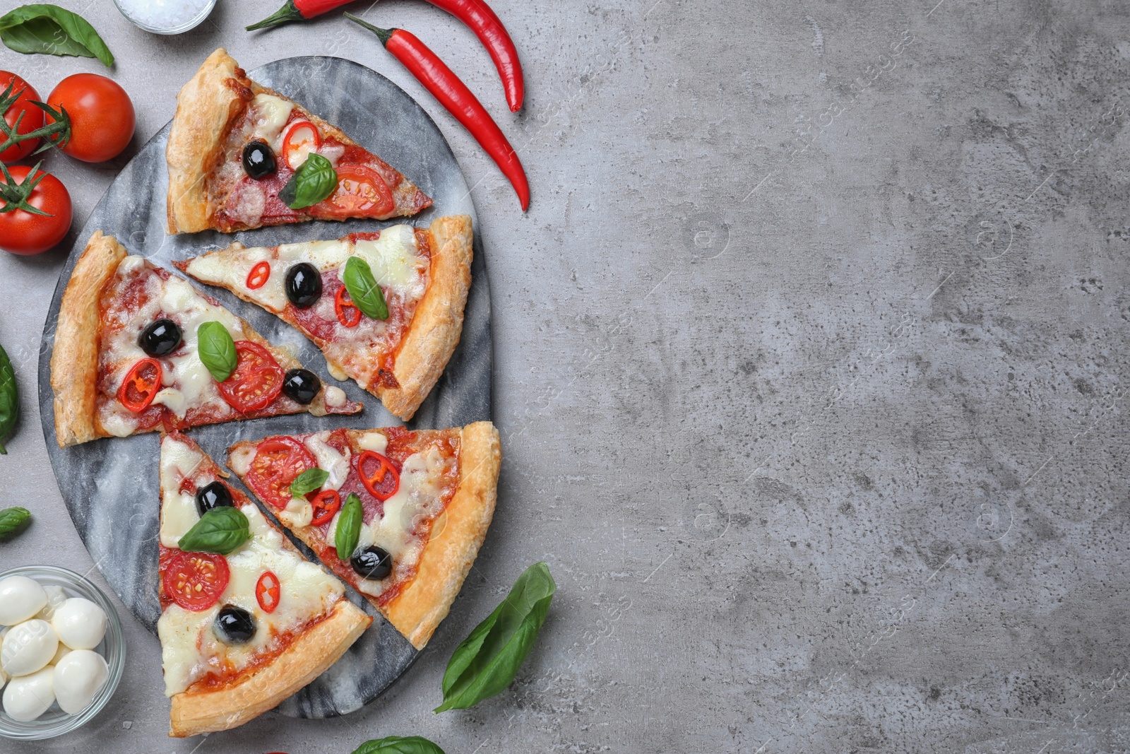 Photo of Pieces of delicious pizza Diablo on grey table, flat lay. Space for text