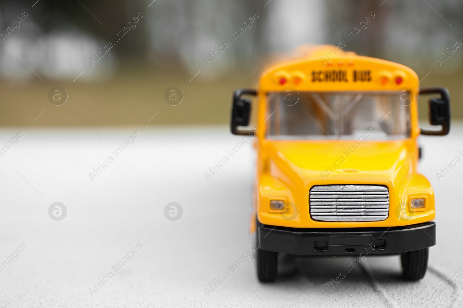 Photo of Closeup view of yellow toy school bus outdoors, space for text. Transport for students