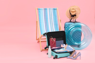 Photo of Deck chair, suitcases and beach accessories on pink background, space for text. Summer vacation