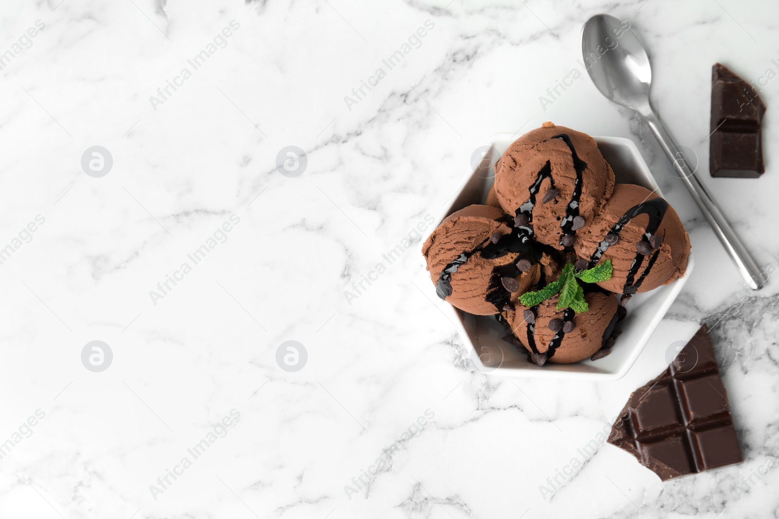 Photo of Flat lay composition with bowl of chocolate ice cream served on marble table, space for text