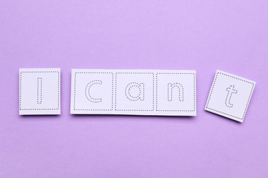 Photo of Motivation concept. Changing phrase from I Can't into I Can by removing paper with letter T on violet background, flat lay