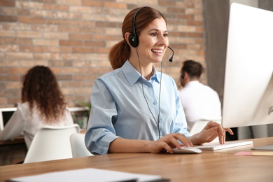 Photo of Technical support operator with headset at workplace