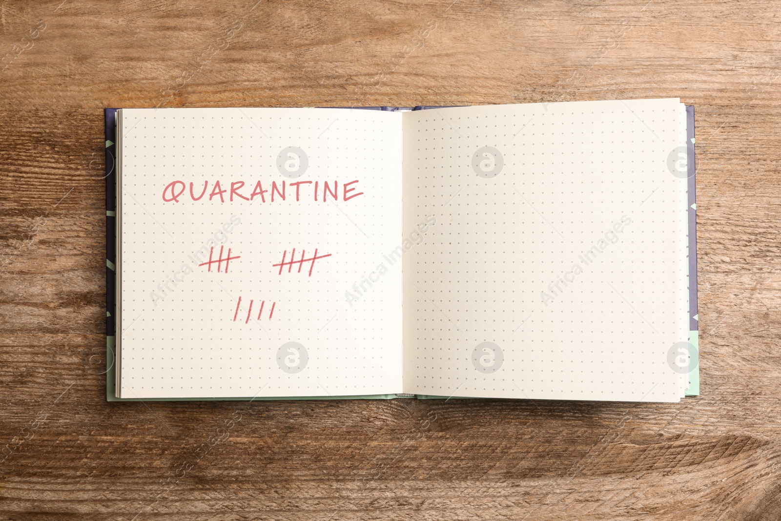 Image of Open notebook on wooden table, top view. Counting days of quarantine during coronavirus outbreak 