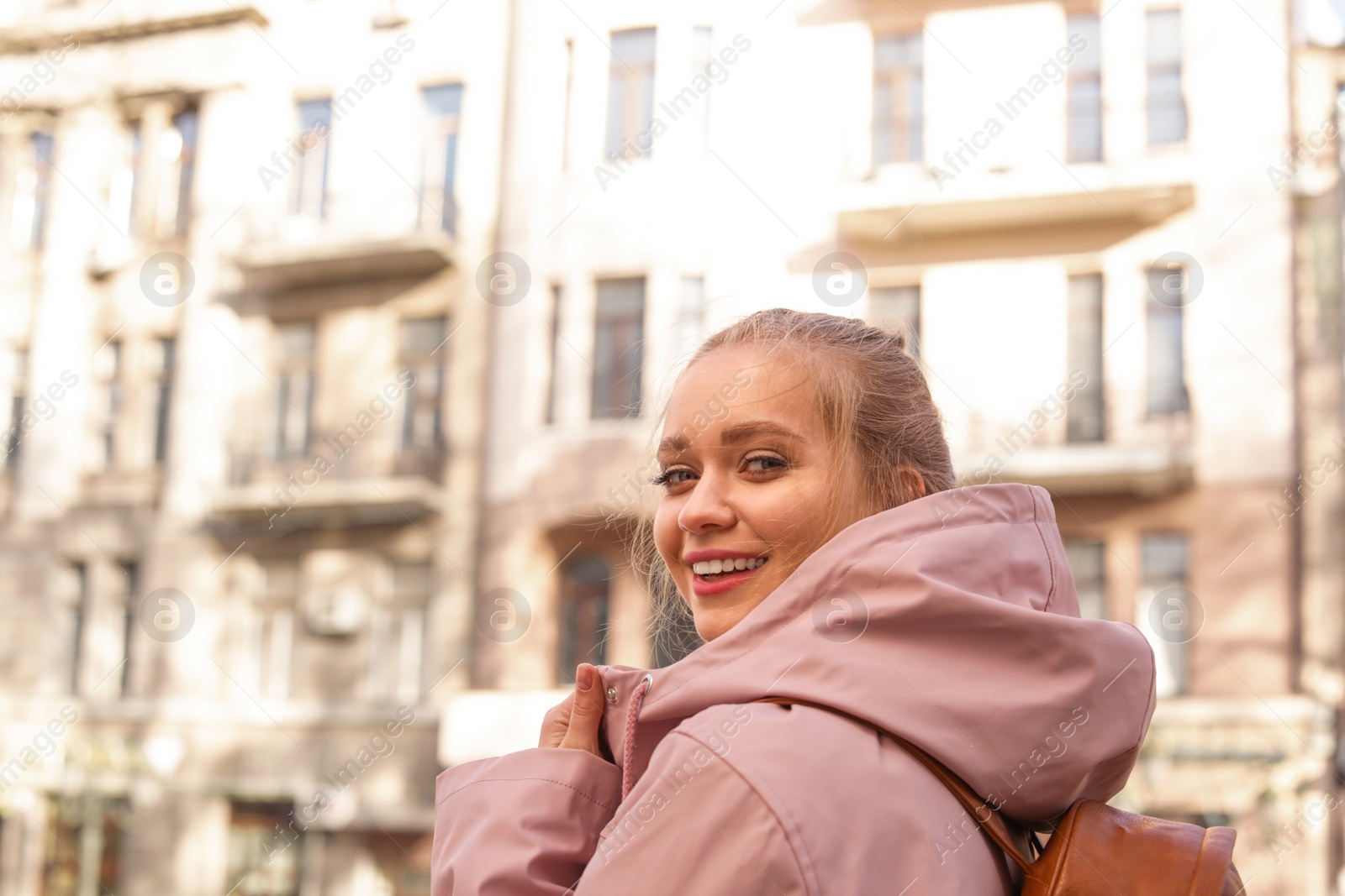 Photo of Portrait of happy young woman on city street