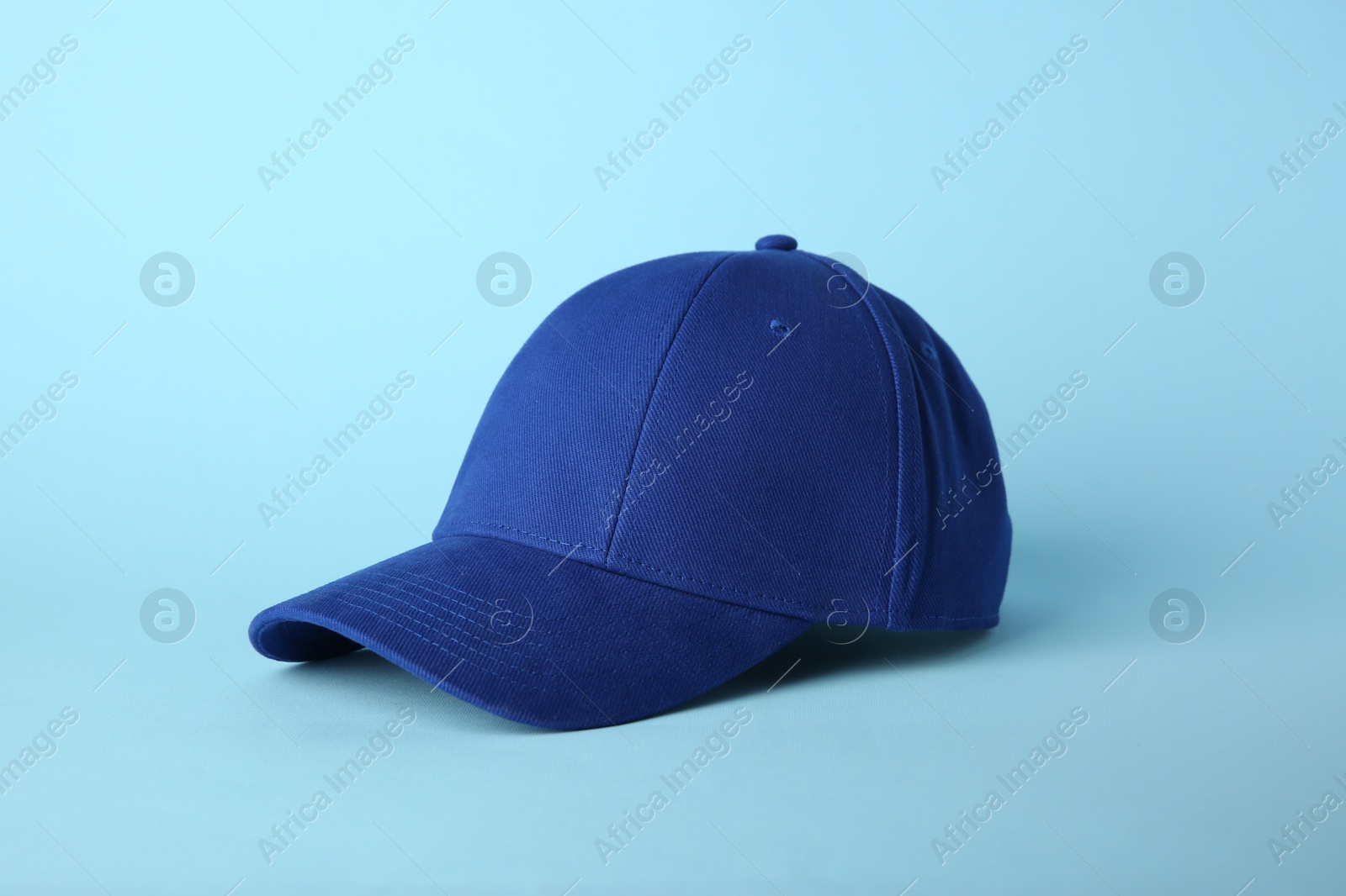 Photo of Stylish baseball cap on light blue background