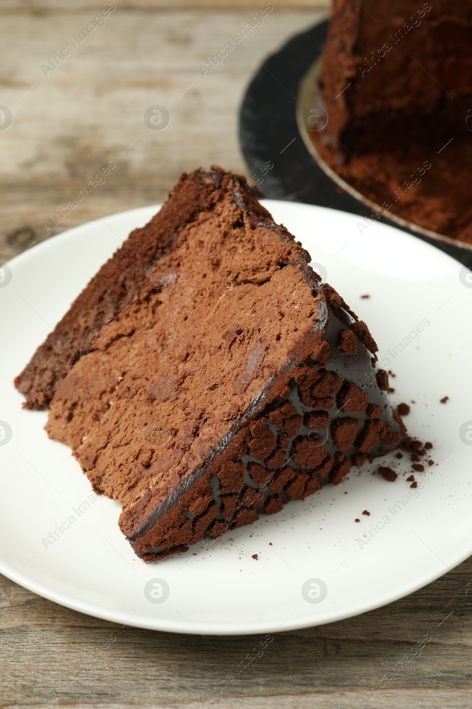 Photo of Piece of delicious chocolate truffle cake on wooden table