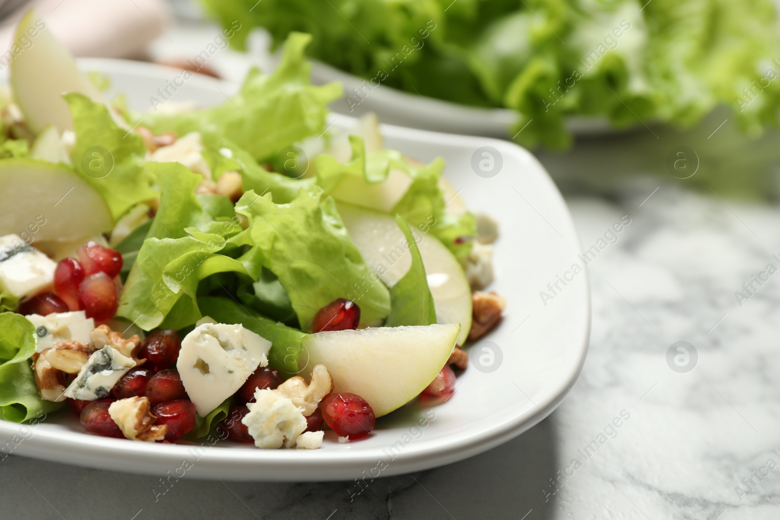 Photo of Tasty salad with pear slices on white table, closeup