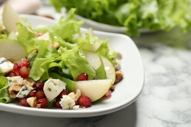 Photo of Tasty salad with pear slices on white table, closeup