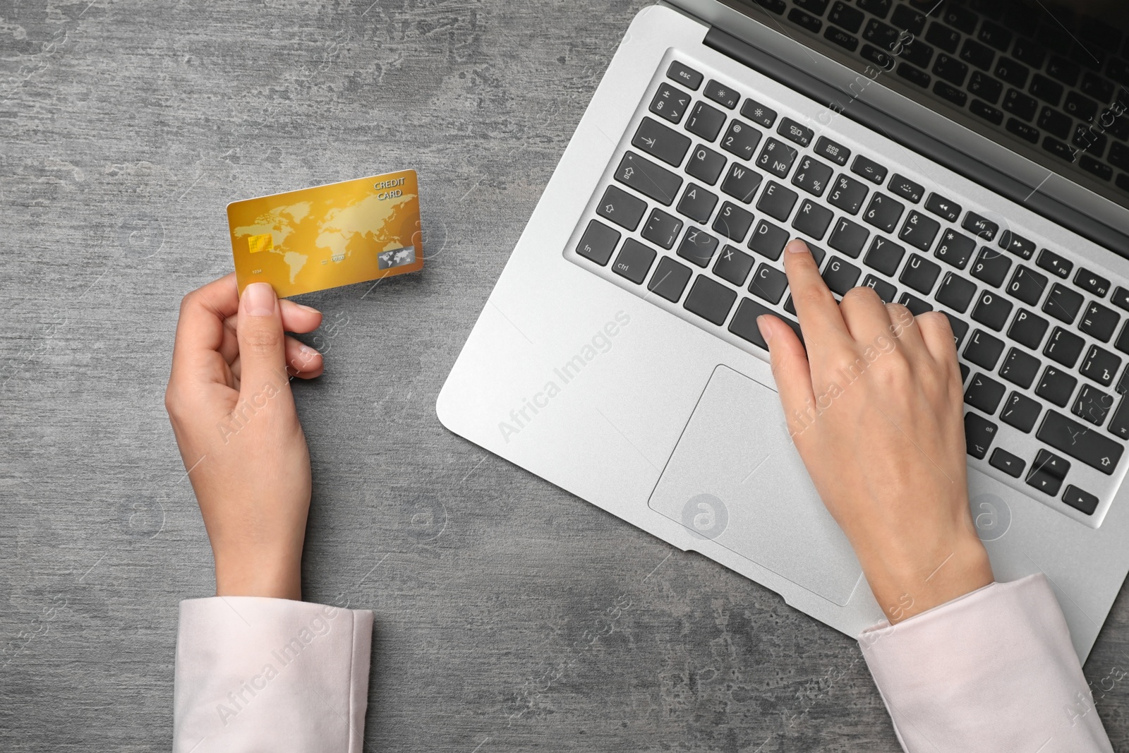 Photo of Woman with credit card using laptop at table, top view