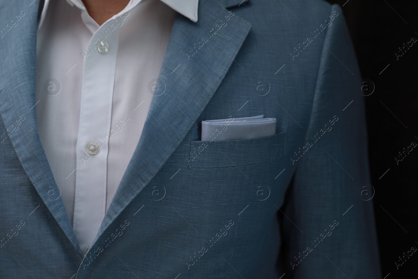 Photo of Man with handkerchief in suit pocket on black background, closeup