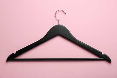 Photo of Black hanger on pink background, top view