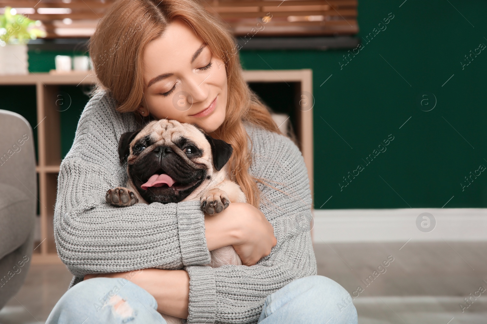 Photo of Woman with cute pug dog at home. Animal adoption