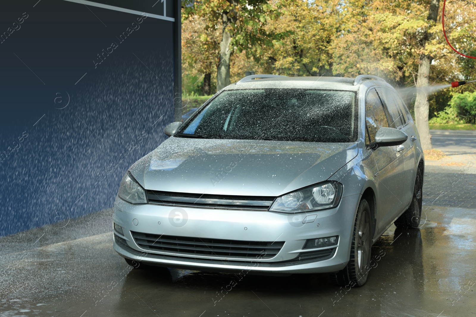 Photo of Washing auto with high pressure water jet at outdoor car wash