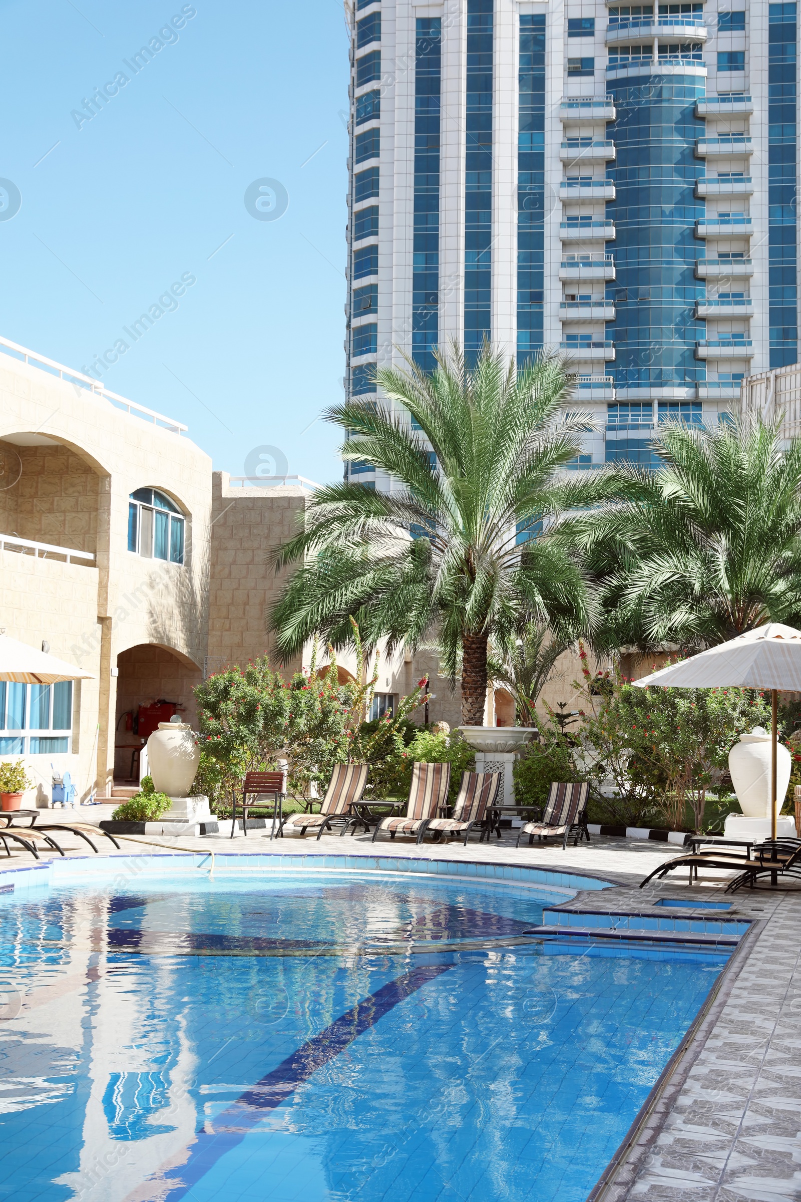 Photo of Modern luxury hotel with swimming pool on sunny day