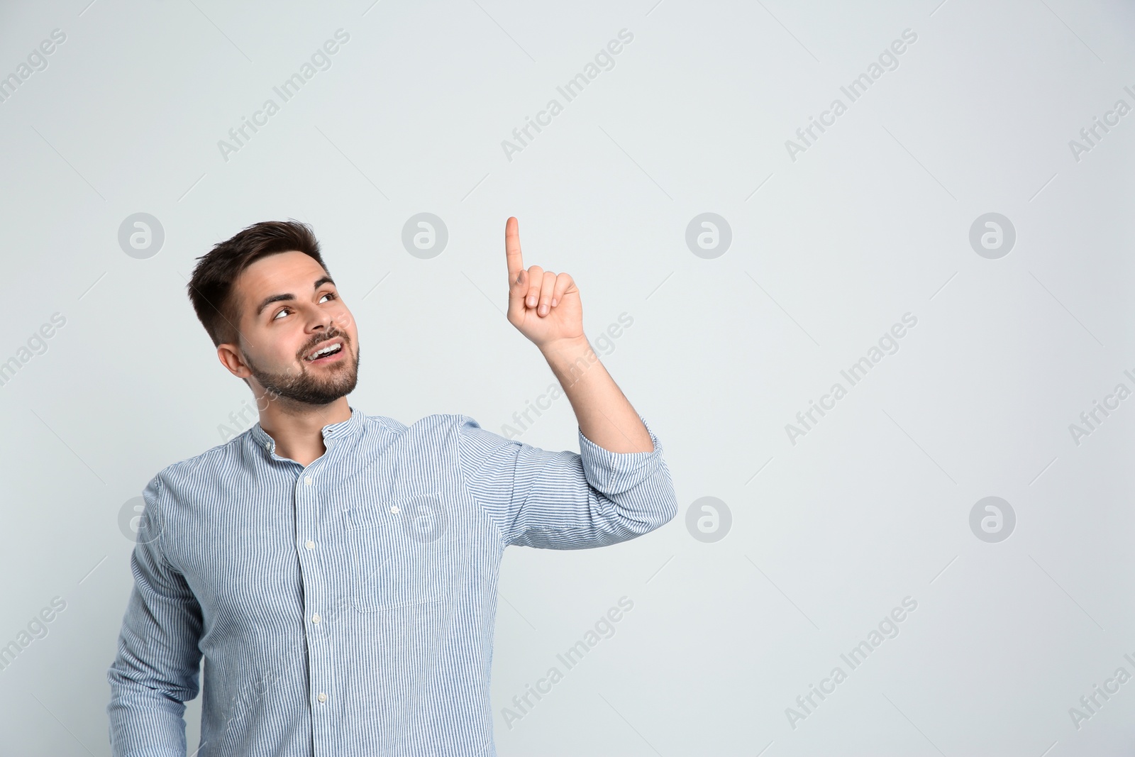 Photo of Happy man on light background, space for text. Thinking about answer to question