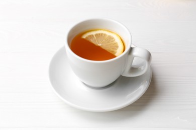 Cup with delicious immunity boosting tea and lemon on white wooden table