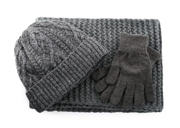 Black woolen gloves, scarf and hat on white background, top view. Winter clothes