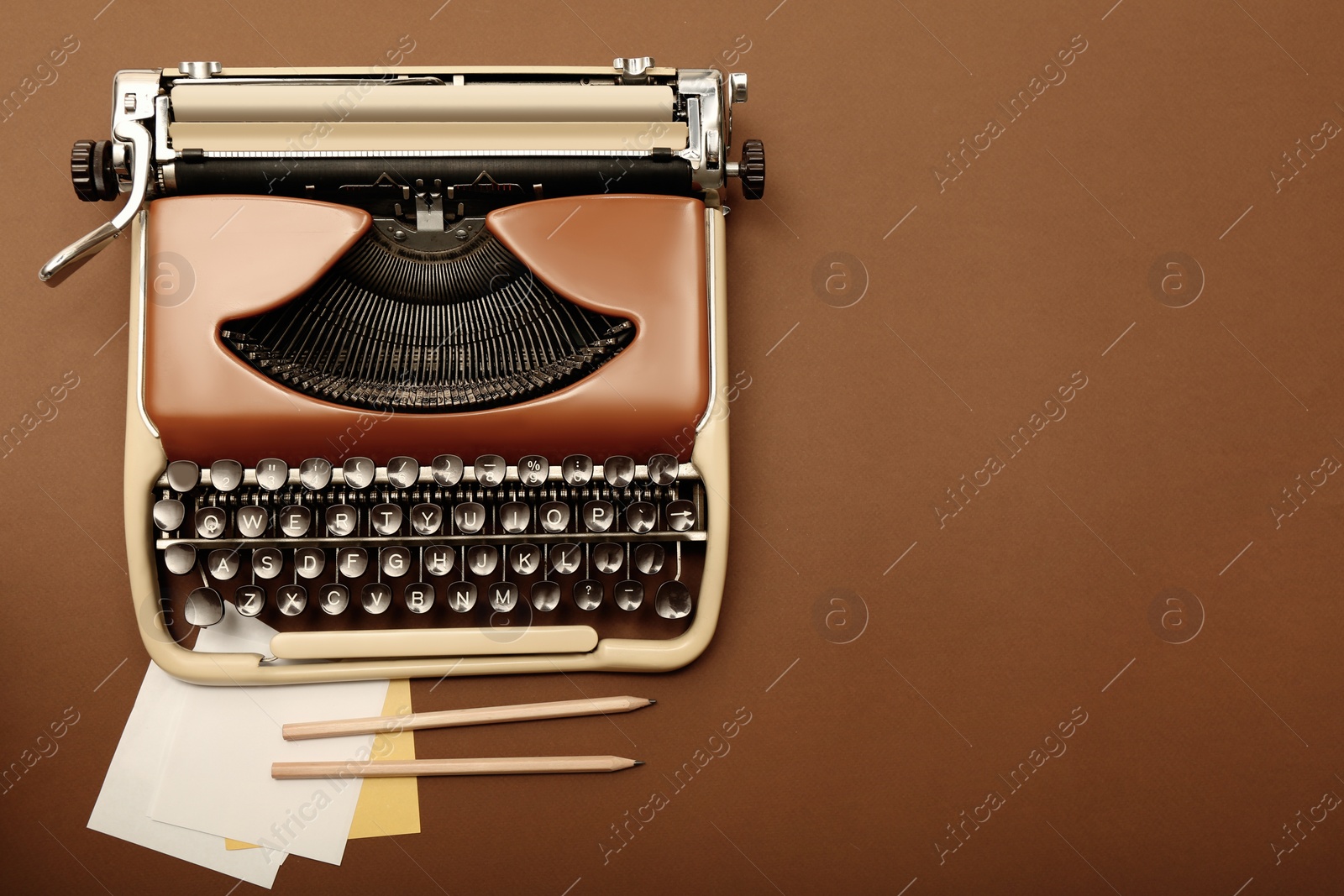 Photo of Vintage typewriter and stationery on brown background, flat lay. Space for text