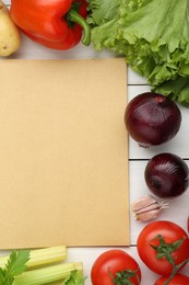 Blank recipe book and different ingredients on white wooden table, flat lay. Space for text