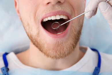 Dentist examining patient's teeth in modern clinic, closeup