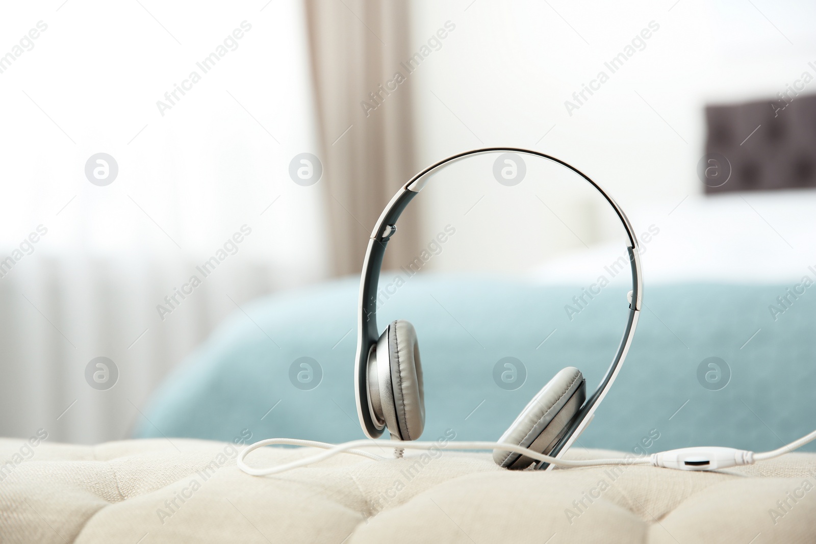 Photo of Stylish headphones on sofa indoors. Space for text